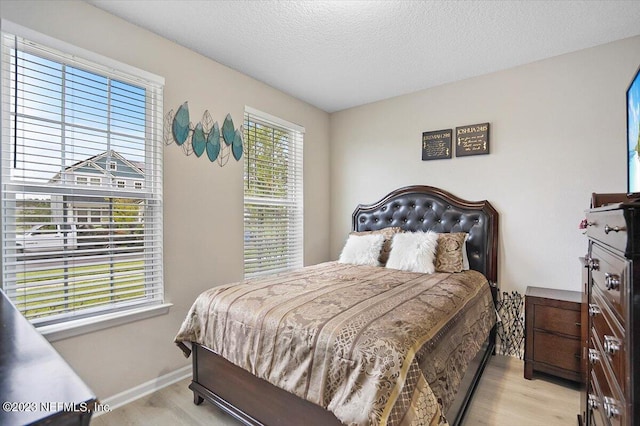 bedroom featuring light wood-type flooring and a textured ceiling