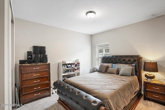 bedroom featuring light colored carpet and a textured ceiling