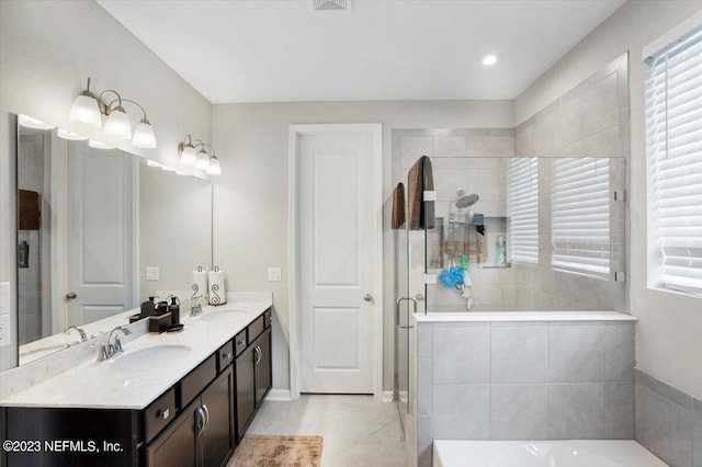 bathroom featuring a shower with door, vanity, tile patterned floors, and a healthy amount of sunlight