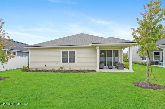 back of house with a lawn and a patio area