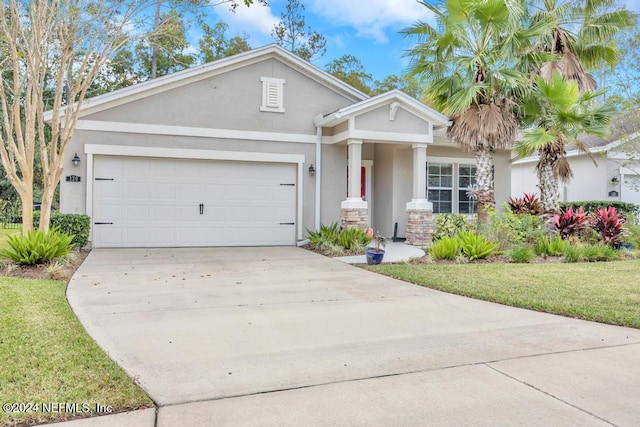 view of front of home with a front yard and a garage