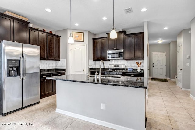 kitchen featuring pendant lighting, dark brown cabinets, decorative backsplash, and appliances with stainless steel finishes