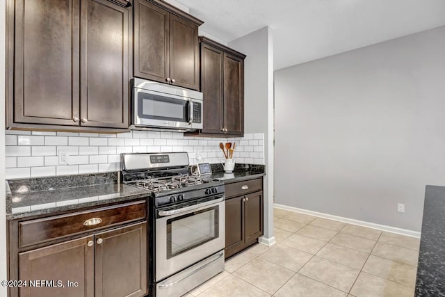 kitchen with dark stone countertops, dark brown cabinetry, appliances with stainless steel finishes, and tasteful backsplash