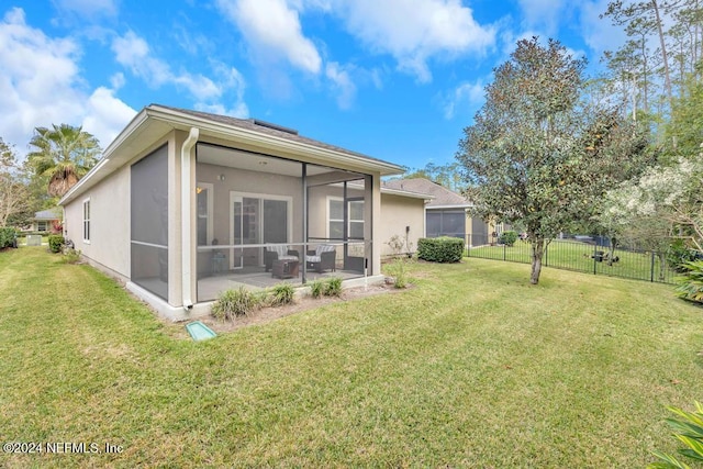 rear view of house featuring a yard, a patio area, and a sunroom