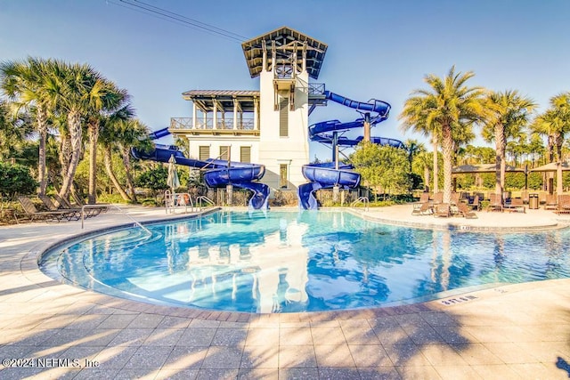 view of swimming pool with a patio area and a water slide