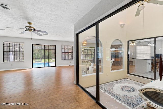 interior space with ceiling fan, light hardwood / wood-style flooring, and a textured ceiling