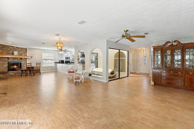 living room with a fireplace, light hardwood / wood-style flooring, and a textured ceiling