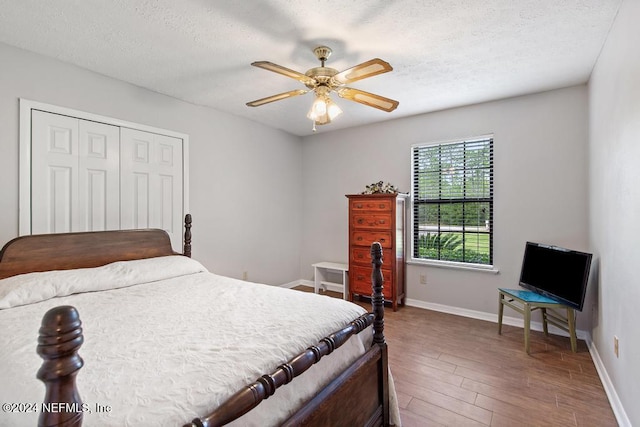 bedroom featuring hardwood / wood-style floors, ceiling fan, a textured ceiling, and a closet