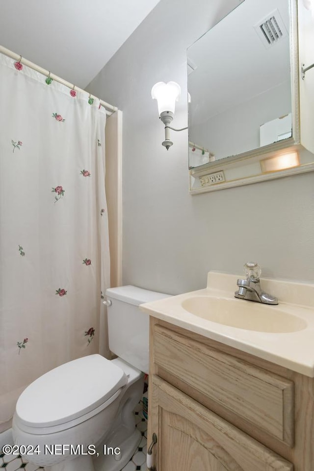 bathroom with tile patterned floors, vanity, toilet, and a shower with curtain