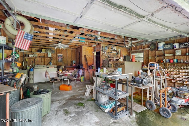 garage with a workshop area, wood walls, and independent washer and dryer