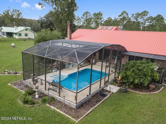 view of pool featuring glass enclosure, a patio area, and a lawn