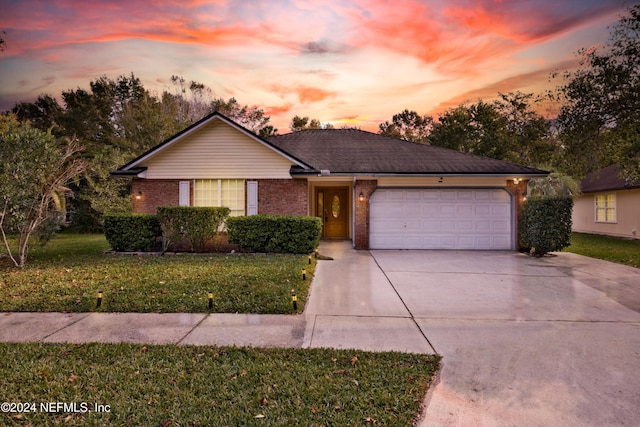 ranch-style house with a yard and a garage