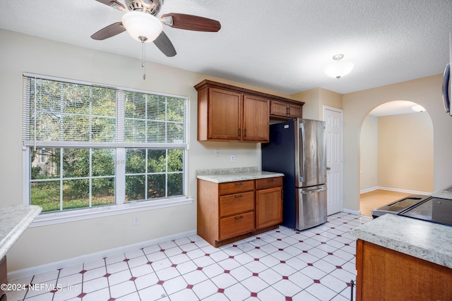 kitchen with stainless steel refrigerator, ceiling fan, and a textured ceiling