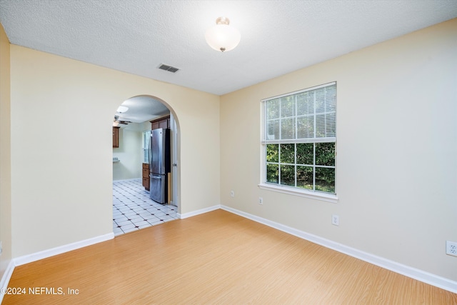 empty room featuring light hardwood / wood-style floors and a textured ceiling