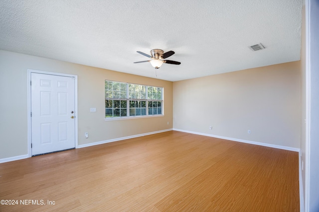 empty room featuring ceiling fan, a textured ceiling, and light hardwood / wood-style flooring