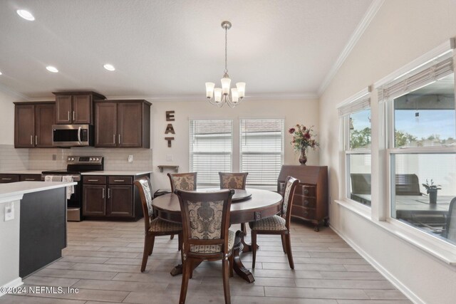 dining room with a chandelier, light hardwood / wood-style floors, and ornamental molding