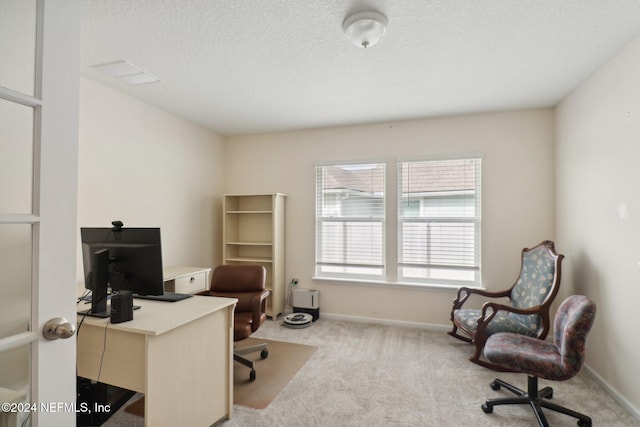 home office featuring light colored carpet and a textured ceiling