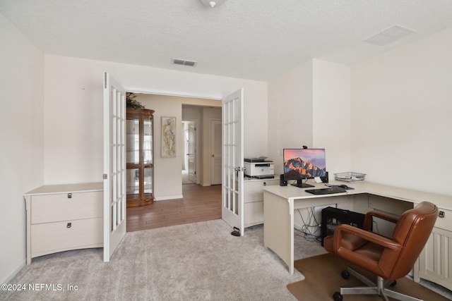 office with light carpet, french doors, and a textured ceiling