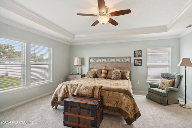 bedroom with a tray ceiling, ceiling fan, crown molding, and light colored carpet