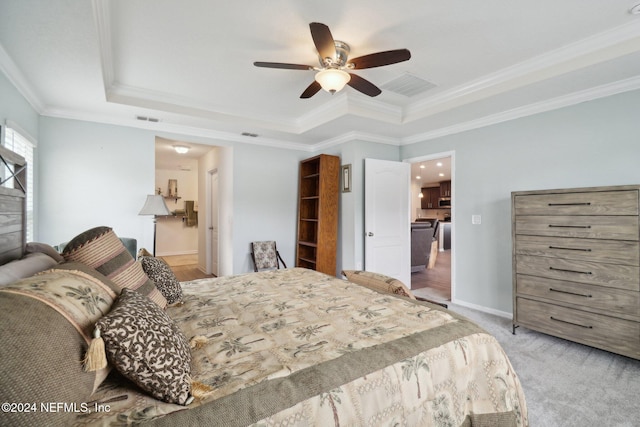 bedroom featuring light colored carpet, ceiling fan, a raised ceiling, and ornamental molding