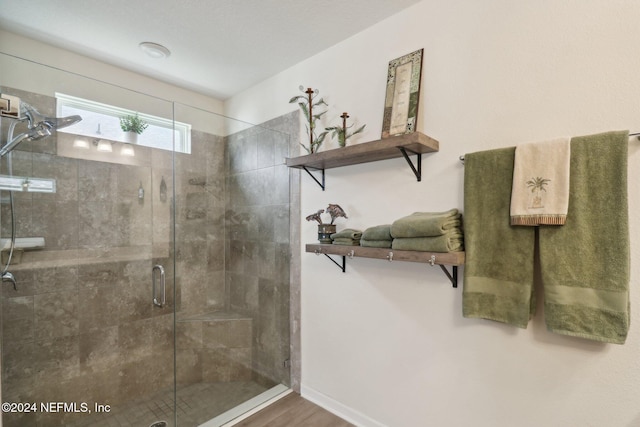 bathroom with an enclosed shower and wood-type flooring