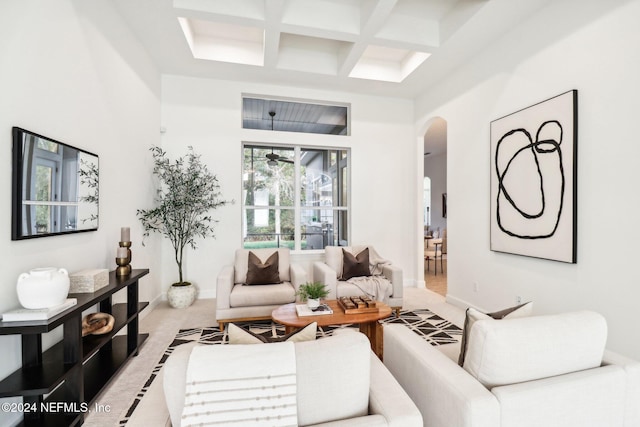 carpeted living room with a high ceiling, coffered ceiling, and beam ceiling