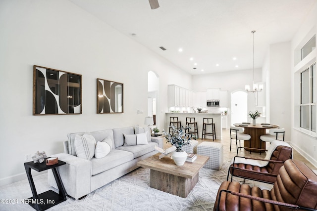 living room with a towering ceiling and a chandelier