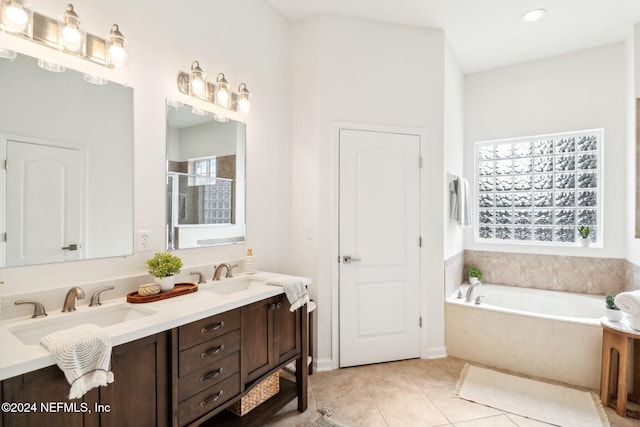 bathroom with plus walk in shower, vanity, tile patterned floors, and plenty of natural light