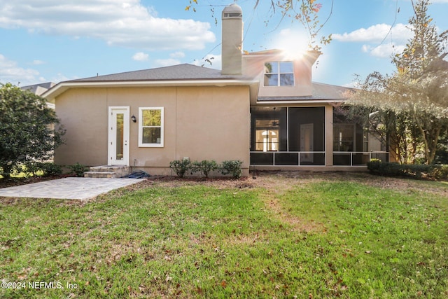 rear view of property featuring a sunroom, a yard, and a patio