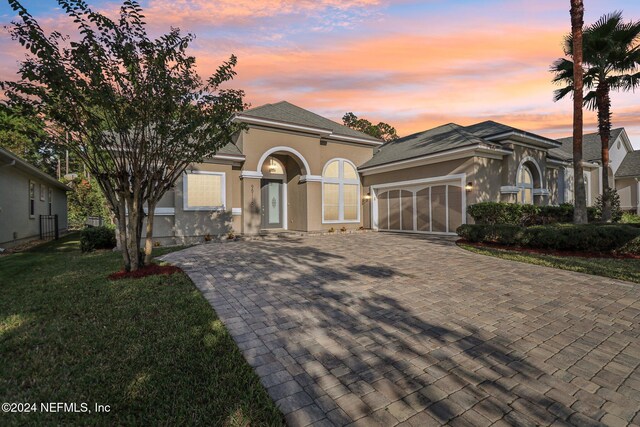 view of front of property featuring a yard and a garage