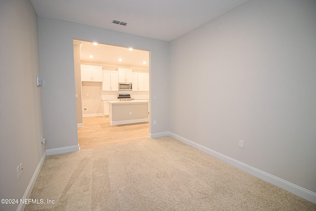 unfurnished living room featuring light colored carpet