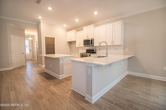 kitchen with light hardwood / wood-style floors, kitchen peninsula, stainless steel appliances, white cabinets, and sink