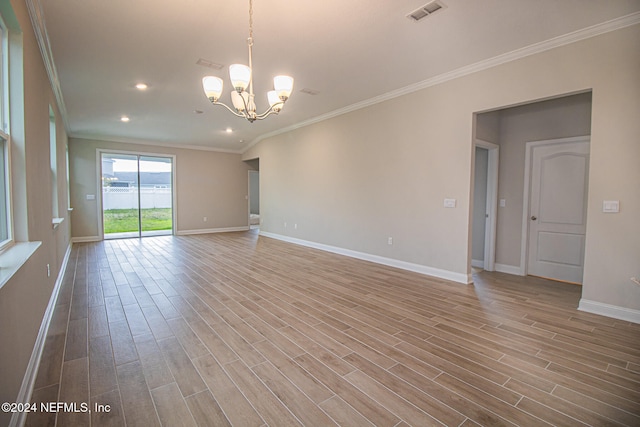 unfurnished room with hardwood / wood-style flooring, ornamental molding, and a notable chandelier