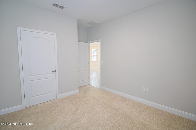 unfurnished bedroom featuring light carpet