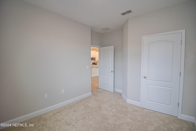 unfurnished bedroom featuring light colored carpet