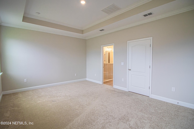 unfurnished bedroom featuring carpet floors, a tray ceiling, connected bathroom, and ornamental molding