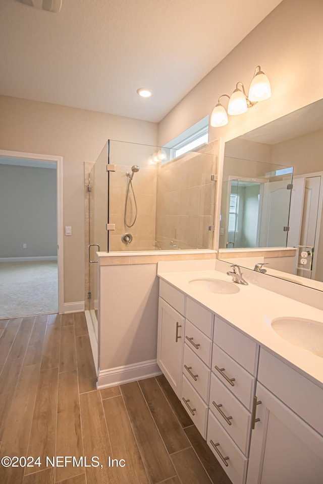 bathroom with a shower with shower door and vanity