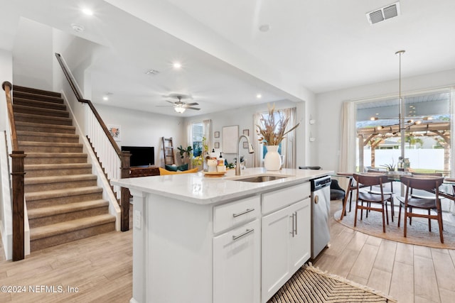 kitchen featuring a center island with sink, white cabinets, light wood-type flooring, and sink