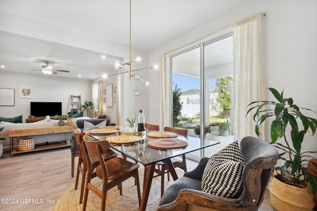 dining space featuring ceiling fan with notable chandelier and light wood-type flooring