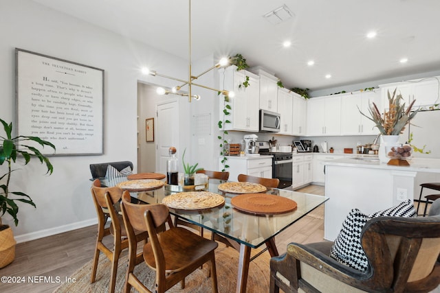 dining area with hardwood / wood-style flooring and an inviting chandelier