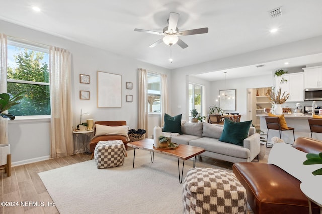 living room with light hardwood / wood-style floors, a wealth of natural light, and ceiling fan