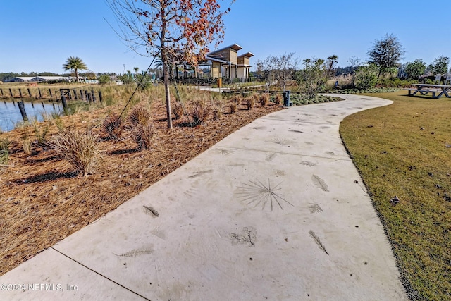 view of home's community with a water view and a yard