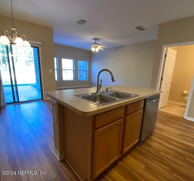 kitchen with dishwasher, a center island with sink, light wood-type flooring, and sink