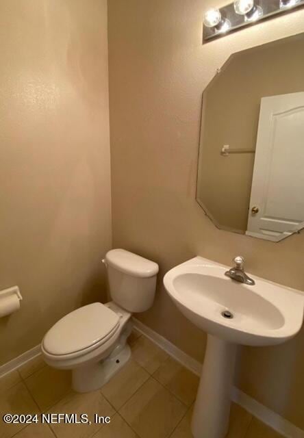 bathroom with toilet and tile patterned floors