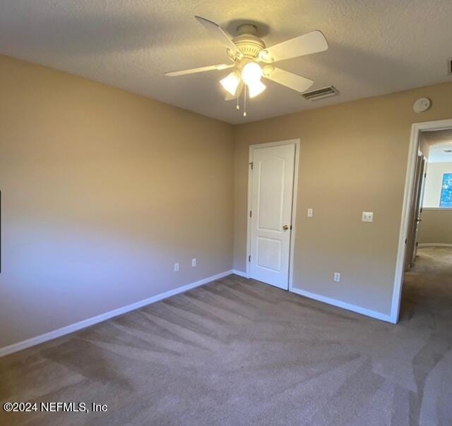 unfurnished bedroom featuring ceiling fan, carpet, and a textured ceiling