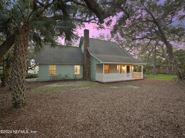 property exterior at dusk featuring a porch