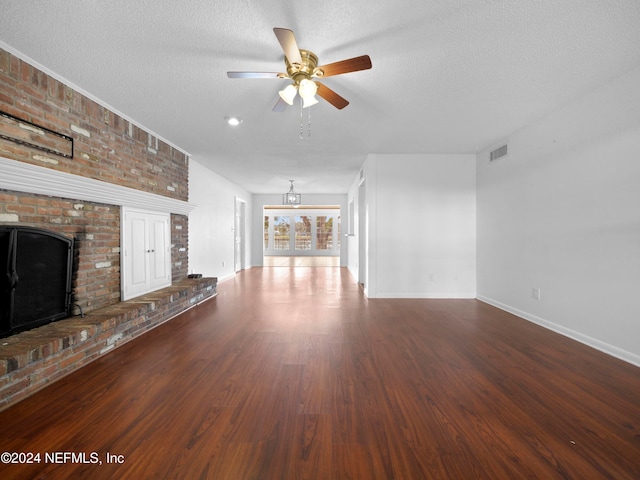 unfurnished living room featuring a textured ceiling, a brick fireplace, hardwood / wood-style flooring, and ceiling fan