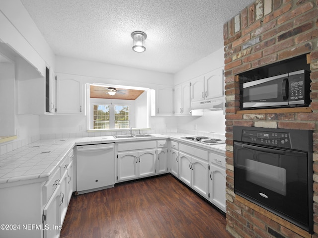 kitchen with tile counters, dark hardwood / wood-style flooring, white cabinets, ceiling fan, and white appliances