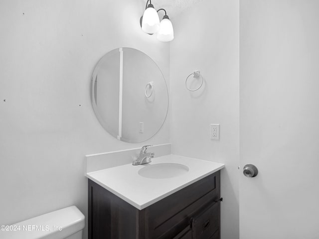 bathroom with vanity, toilet, and a textured ceiling