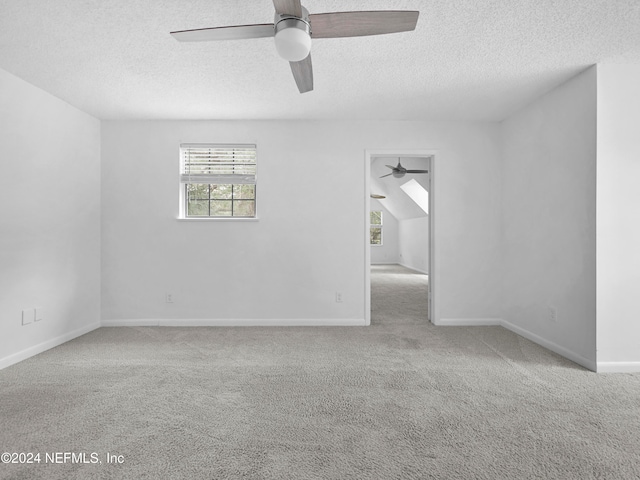 empty room with a textured ceiling, light carpet, and ceiling fan